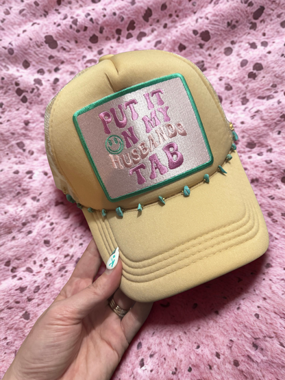 Put It On My Husbands Tab Trucker Hat